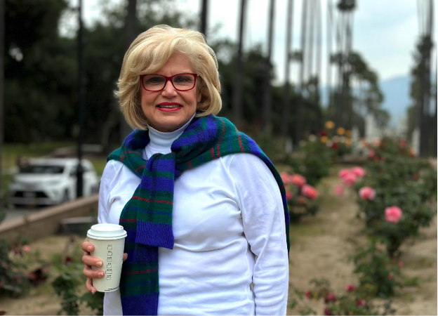 Dr. Susan Chobanian smiling outdoors holding coffee